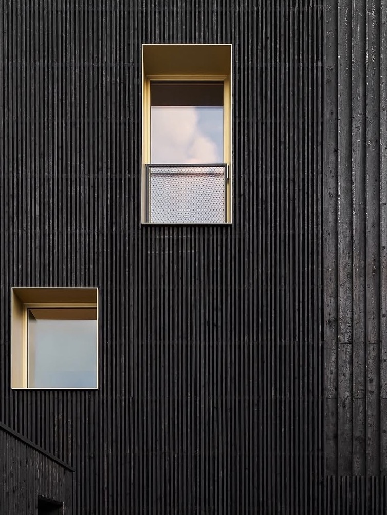 Referenzdetail: dunkles Holz und warme Fensterfassung